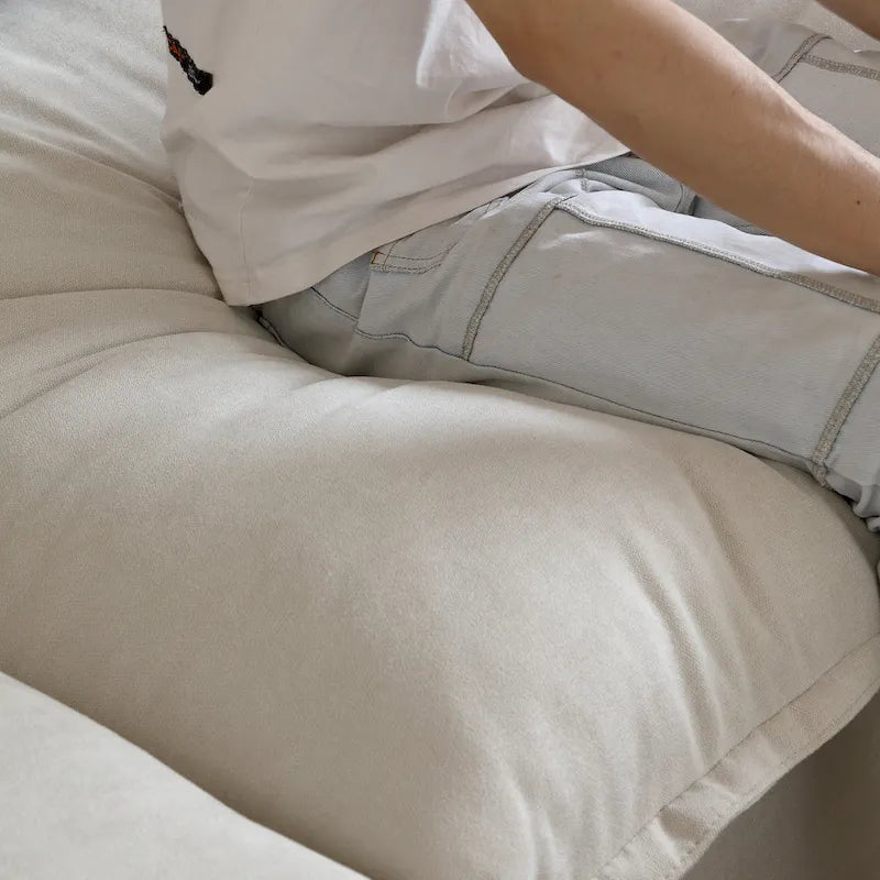 Canapé d'angle moderne en lin avec pouf, en forme de L.