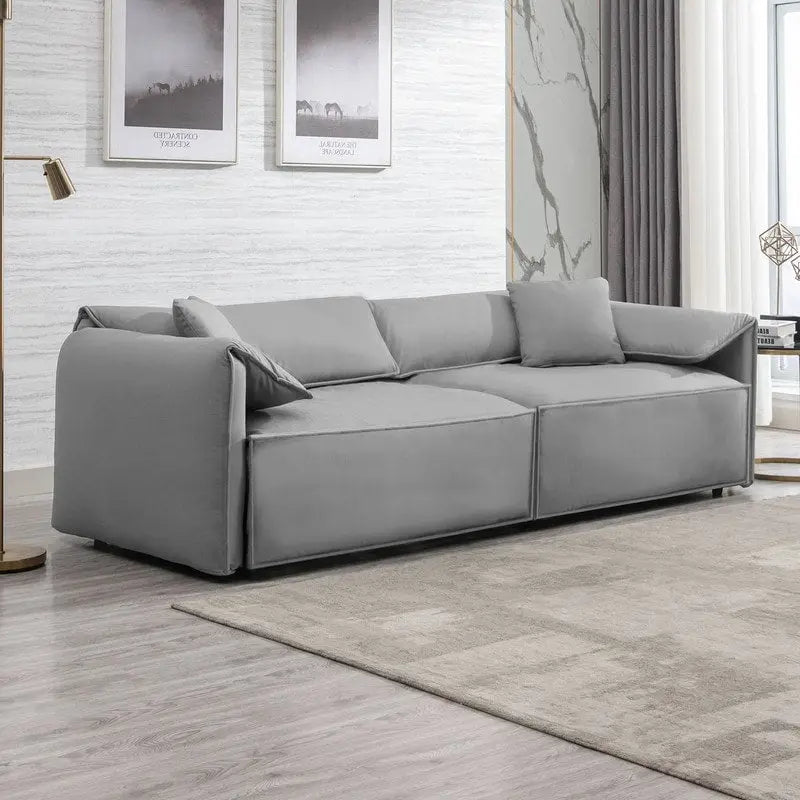 Canapé Mixoy 4 places à assise profonde et rembourrée, style italien minimaliste, 97 cm, avec accoudoirs en forme d'oreilles d'éléphant et coussin décoratif.
