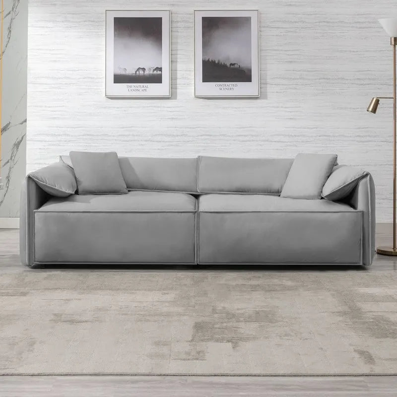 Canapé Mixoy 4 places à assise profonde et rembourrée, style italien minimaliste, 97 cm, avec accoudoirs en forme d'oreilles d'éléphant et coussin décoratif.