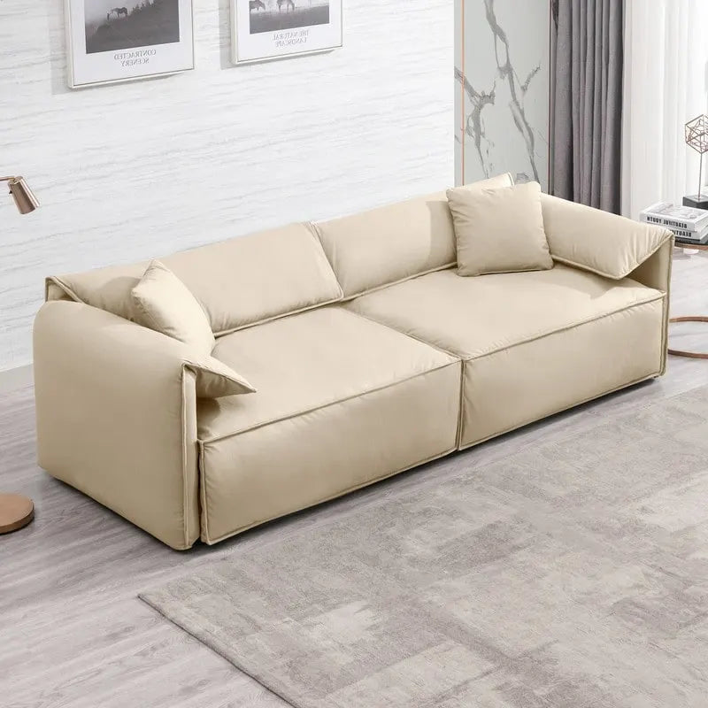 Canapé Mixoy 4 places à assise profonde et rembourrée, style italien minimaliste, 97 cm, avec accoudoirs en forme d'oreilles d'éléphant et coussin décoratif.