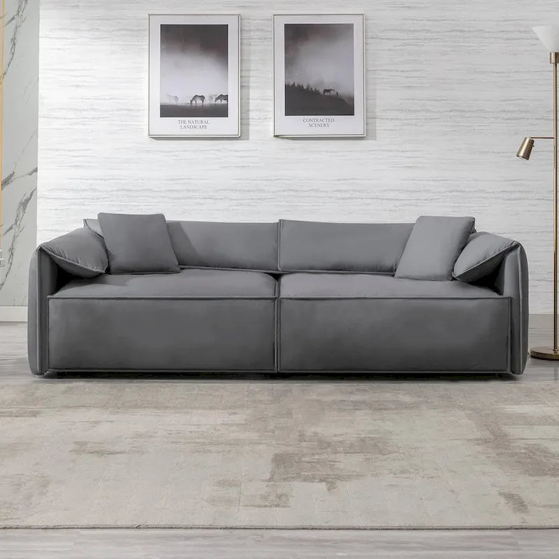 Canapé Mixoy 4 places à assise profonde et rembourrée, style italien minimaliste, 97 cm, avec accoudoirs en forme d'oreilles d'éléphant et coussin décoratif.