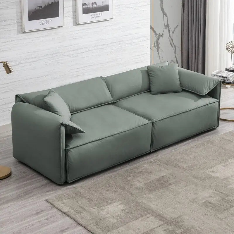 Canapé Mixoy 4 places à assise profonde et rembourrée, style italien minimaliste, 97 cm, avec accoudoirs en forme d'oreilles d'éléphant et coussin décoratif.