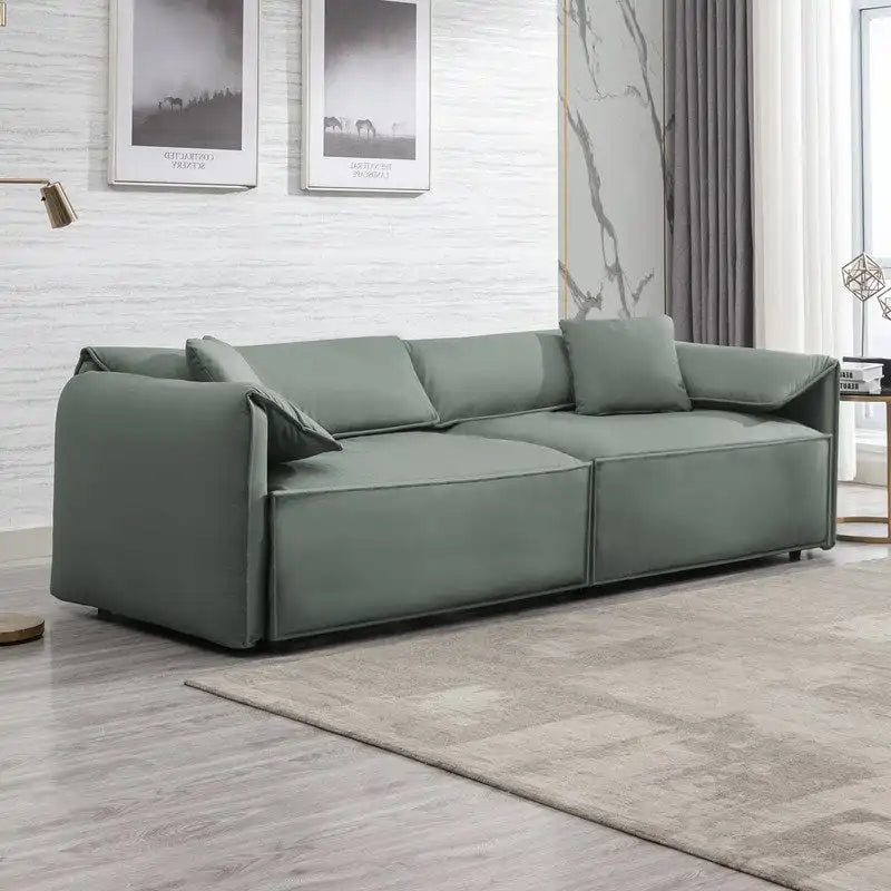 Canapé Mixoy 4 places à assise profonde et rembourrée, style italien minimaliste, 97 cm, avec accoudoirs en forme d'oreilles d'éléphant et coussin décoratif.