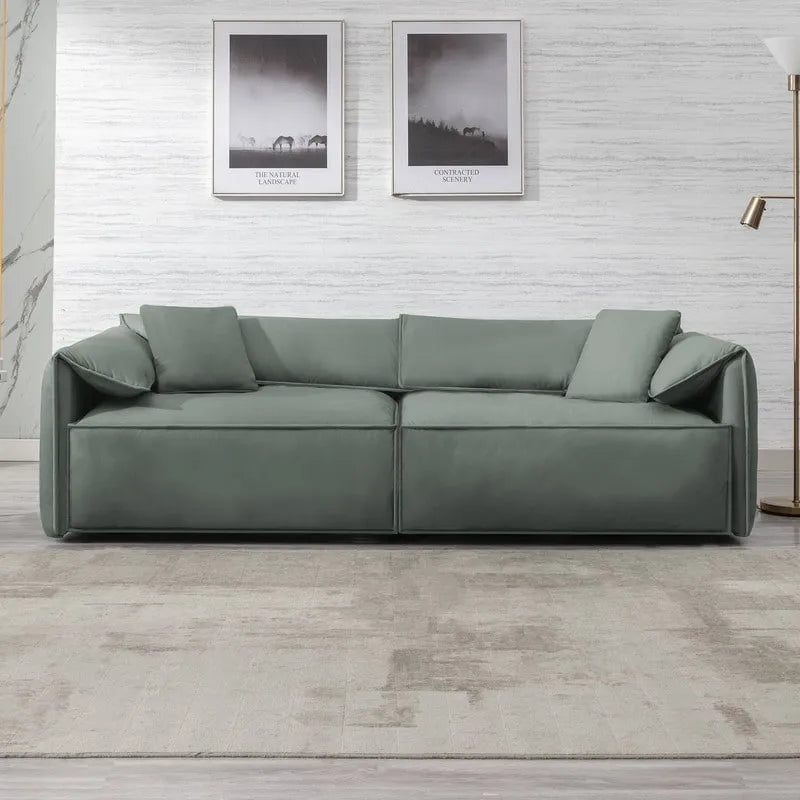 Canapé Mixoy 4 places à assise profonde et rembourrée, style italien minimaliste, 97 cm, avec accoudoirs en forme d'oreilles d'éléphant et coussin décoratif.